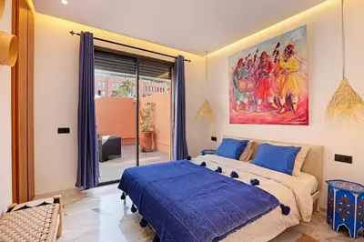a bedroom with a bed and a painting on the wall at Heart of City 2BR 2Patios Fiber AC Modern New Calm in Marrakech