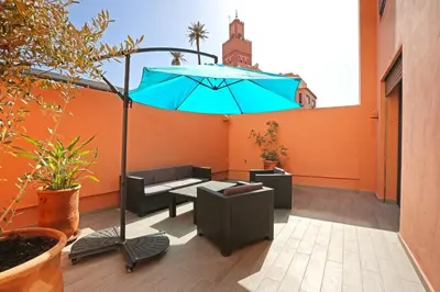 a patio with a table and a blue umbrella at Heart of City 2BR 2Patios Fiber AC Modern New Calm in Marrakech