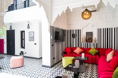 a living room with a red couch and black and white stripes at Riad Looma in Marrakech