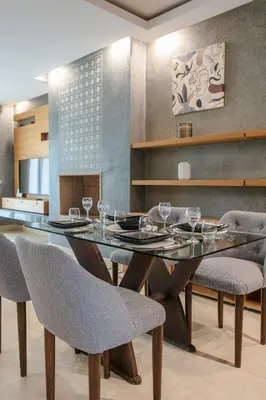 a dining room with a glass table and chairs at Bel appartement vue sur piscine, fibre optique, parking gratuit in Marrakech