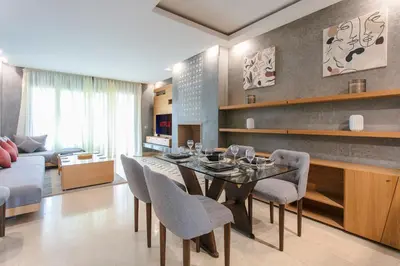 a living room with a dining room table and chairs at Bel appartement vue sur piscine, fibre optique, parking gratuit in Marrakech
