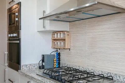 a kitchen with a stove and a counter top at Bel appartement vue sur piscine, fibre optique, parking gratuit in Marrakech