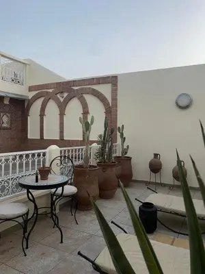 a patio with tables and chairs and potted plants at Riad zouina in Marrakech
