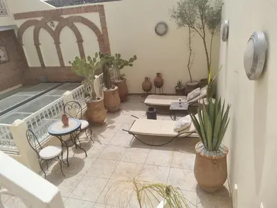 a balcony with tables and chairs and potted plants at Riad zouina in Marrakech
