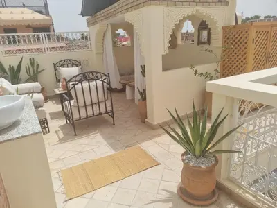 a balcony with a table and a potted plant at Riad zouina in Marrakech