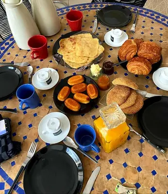 a table with plates of food and pastries on it at Riad zouina in Marrakech