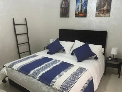 a bedroom with a bed with blue and white pillows at Elegant Apartment in Marrakech Gueliz in Marrakech