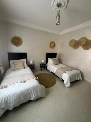 a bedroom with two beds and a circular rug at Elegant Apartment in Marrakech Gueliz in Marrakech