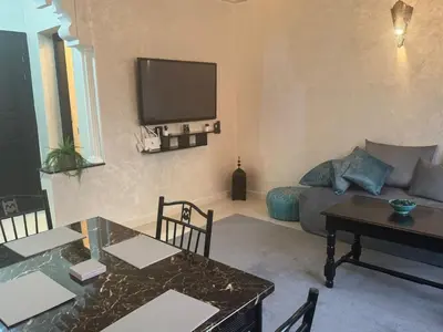 a living room with a table and a tv on the wall at Elegant Apartment in Marrakech Gueliz in Marrakech
