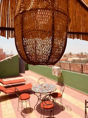 a patio with chairs and a table and a chandelier at Appartement cosy au coeur des souks de Marrakech in Marrakech