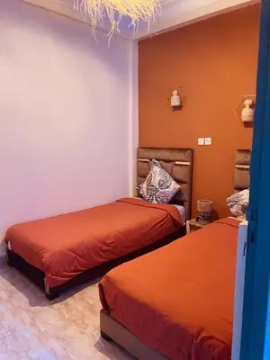 a bedroom with two beds and a chandelier at Appartement cosy au coeur des souks de Marrakech in Marrakech