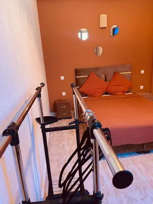 a bedroom with a bed with orange pillows and a baseball bat at Appartement cosy au coeur des souks de Marrakech in Marrakech