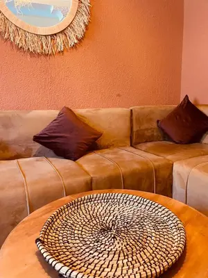 a living room with a brown couch with a table at Appartement cosy au coeur des souks de Marrakech in Marrakech