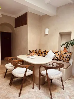 a table and chairs in a room with a couch at Momo House- Riad Zaza in Marrakech