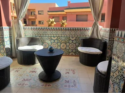 a patio with chairs and stools on a balcony at Central Fiber Optic Pool in Marrakech