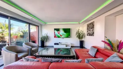 a living room with red couches and a tv at Exceptional View & Hot Tub Marrakesh in Marrakech