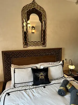 a bedroom with a bed with a large mirror on the wall at Dar Mezhor apartment in Marrakech