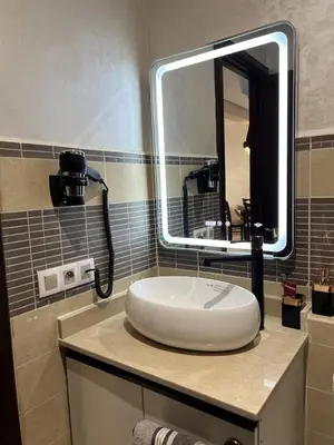 a bathroom with a sink and a large mirror at Dar Mezhor apartment in Marrakech