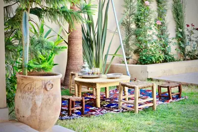 a patio with a table and chairs and plants at Villa El Ilham réservée aux familles in Marrakech