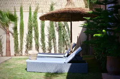 a chair and an umbrella in a yard at Villa El Ilham réservée aux familles in Marrakech