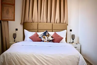 a bedroom with a bed with white sheets and pillows at Villa El Ilham réservée aux familles in Marrakech