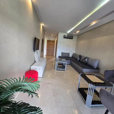 a living room with a couch and a tv at Luxury Flat 2 Bedrooms Prestigia Golf City in Marrakech