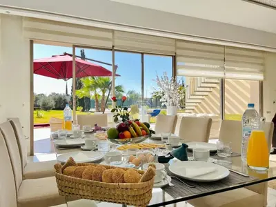 a dining room with a table with food on it at Spacious Villa with Mountain Views - 550 m² in Marrakech