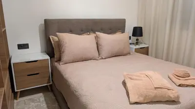 a bedroom with a bed with pillows and a night stand at Stylish Apart Near City Center in Marrakech