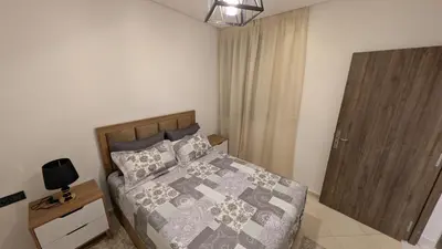 a bedroom with a bed and a wooden door at Stylish Apart Near City Center in Marrakech