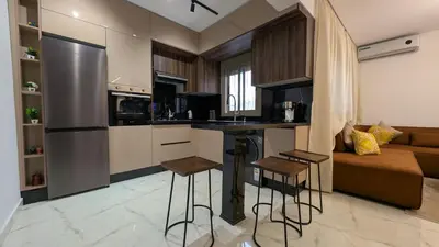 a kitchen with a bar and a couch in a room at Stylish Apart Near City Center in Marrakech