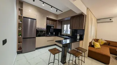 a kitchen with a bar and a couch in a room at Stylish Apart Near City Center in Marrakech