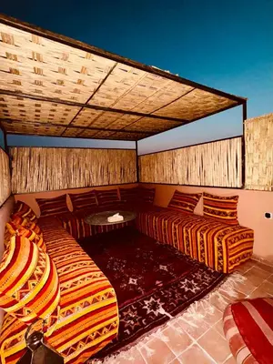 a room with two beds and a table at Riad Kimme Room 1 in Marrakech