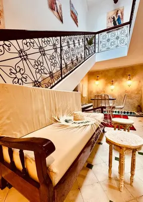 a bed in a room with a staircase and tables at Riad Kimme Room 1 in Marrakech