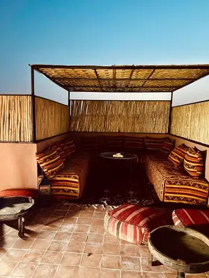 a room with two beds and a table and chairs at Riad Kimme Room 1 in Marrakech