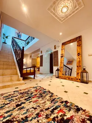 a living room with a rug on the floor and a staircase at Riad Kimme Room 1 in Marrakech