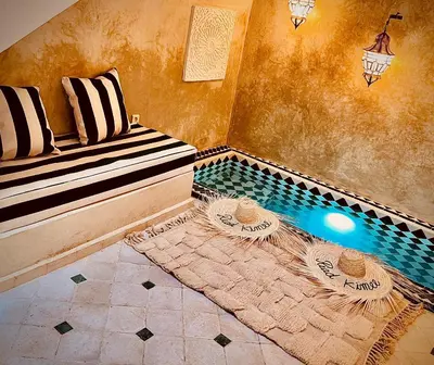 a room with a pool with a bench and a table at Riad Kimme Room 1 in Marrakech