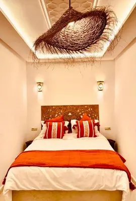 a bedroom with a large bed with a basket on the ceiling at Riad Kimme Room 1 in Marrakech