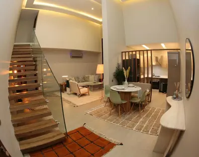 a living room with a staircase and a dining room at Charming duplex appartment in Marrakech