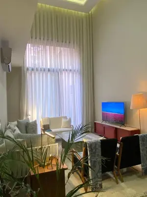 a living room with a couch and a laptop on a window at Charming duplex appartment in Marrakech
