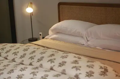 a bed with pillows on it with a lamp next to it at Charming duplex appartment in Marrakech