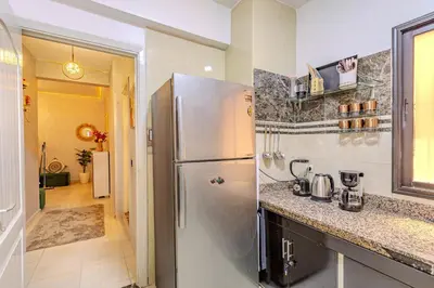 a kitchen with a stainless steel refrigerator next to a hallway at Oasis de charme au cœur de Marrakech in Marrakech