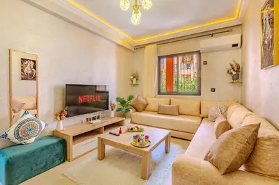 a living room with a couch and a tv at Oasis de charme au cœur de Marrakech in Marrakech