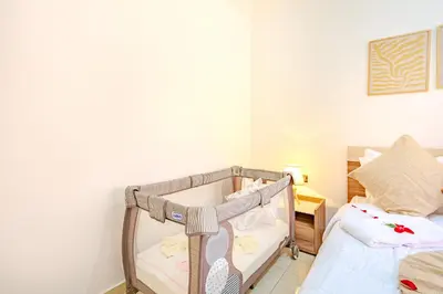 a baby crib in a room with a bed at Oasis de charme au cœur de Marrakech in Marrakech