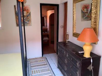 a room with a dresser and a mirror and a lamp at Comfortable house with pool in Marrakech