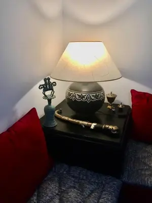 a lamp on a table next to a bed at Comfortable house with pool in Marrakech