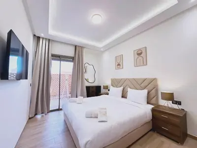a bedroom with a large white bed and a balcony at Modernes Apartment in Top-Lage in Guéliz Marrakech in Marrakech