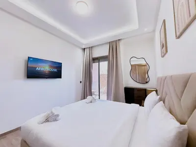 a hotel room with a bed and a tv at Modernes Apartment in Top-Lage in Guéliz Marrakech in Marrakech
