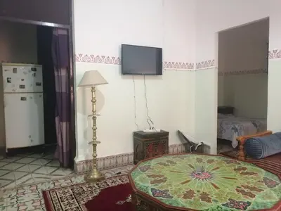 a living room with a table and a tv on the wall at Apartment 3 mins Place jamaa el fana in Marrakech