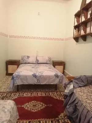 a bedroom with a bed in the corner of a room at Apartment 3 mins Place jamaa el fana in Marrakech