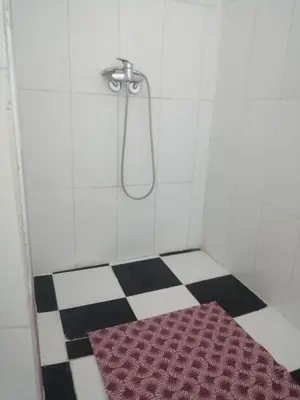 a bathroom with a shower with a red rug on the floor at Apartment 3 mins Place jamaa el fana in Marrakech